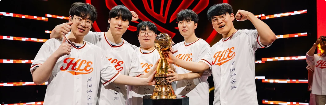 Een professioneel esports-team viert op het podium een toernooioverwinning terwijl het de kampioenschapstrofee omhoog houdt voor een juichende menigte.