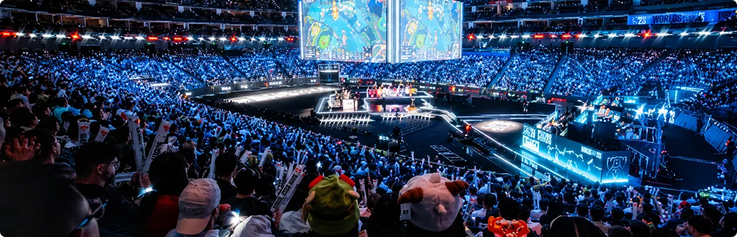 Een bomvolle esports-arena met een groot centraal podium, gameschermen en duizenden toeschouwers die naar een live-toernooi kijken.